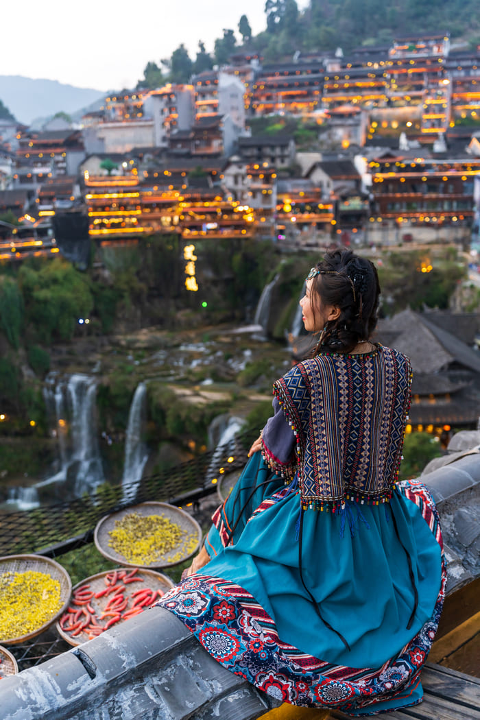 mujeres asiáticas sentadas frente a la ciudad de LIJIANG CHINA